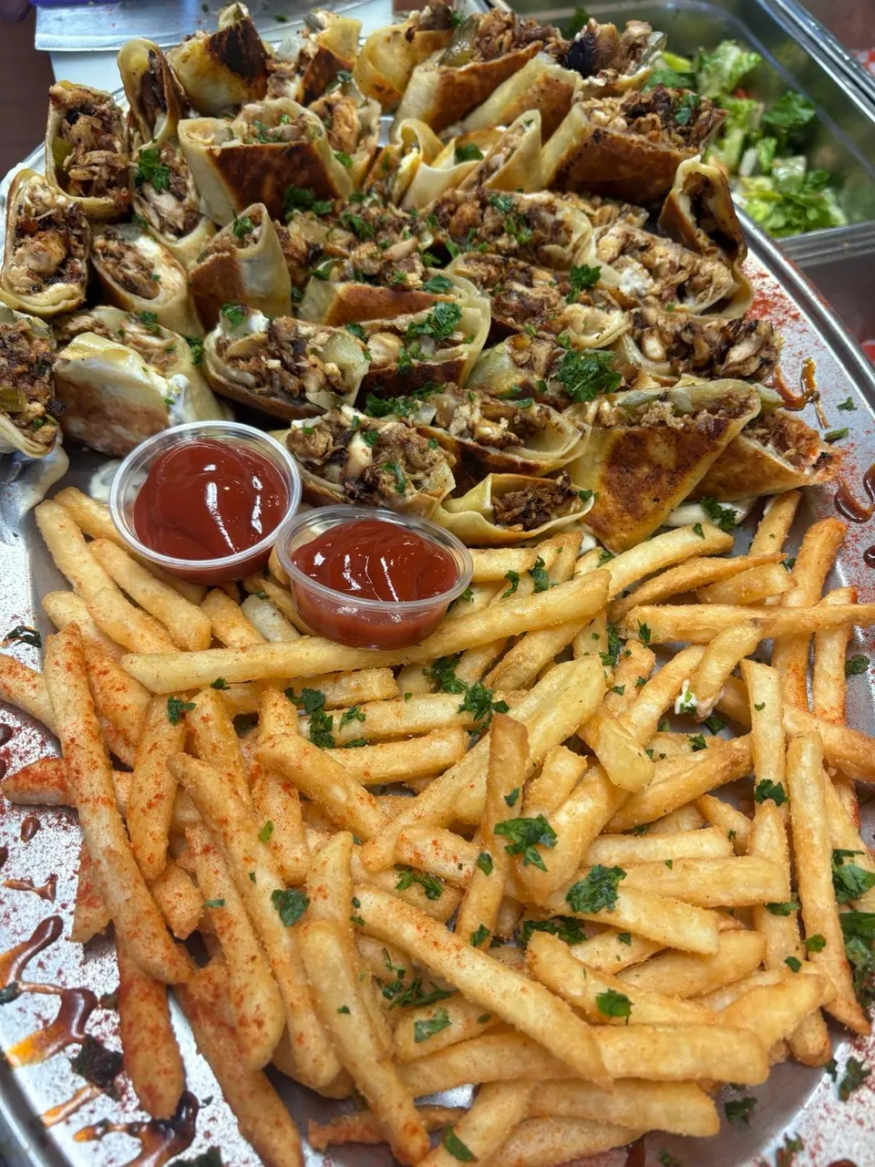 A large Palmyra shawarma platter with sliced wraps, fries and dips